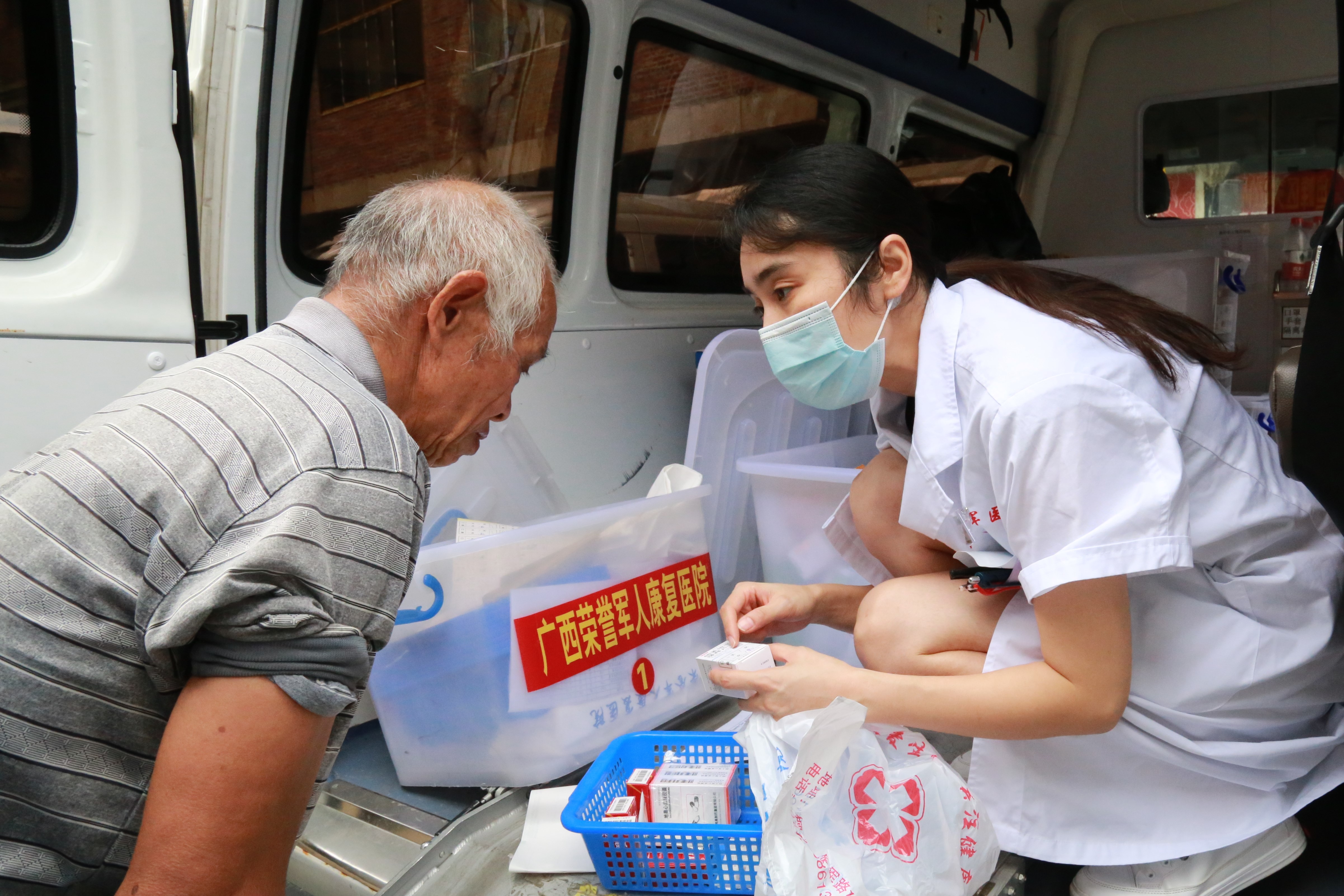 图为巡诊医疗队工作人员为在乡退役军人免费发放药品并交待相关事项。.JPG